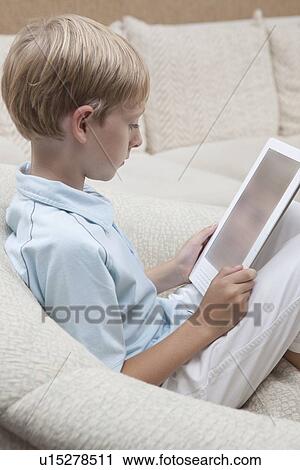 Boy reads a digital book View Large Photo Image Stock Image - Boy reads a digital book. Fotosearch