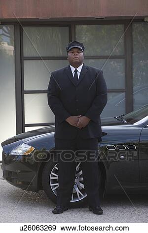 Chauffeur stands with hands clapsed at luxury vehicle View Large Photo Image Stock Photo - Chauffeur stands with hands clapsed at luxury vehicle. Fotosearch