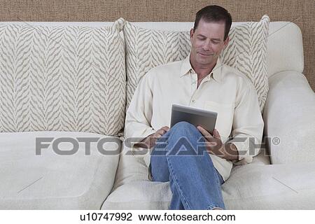 Man sits reading a digital book View Large Photo Image Stock Image - Man sits reading a digital book. Fotosearch