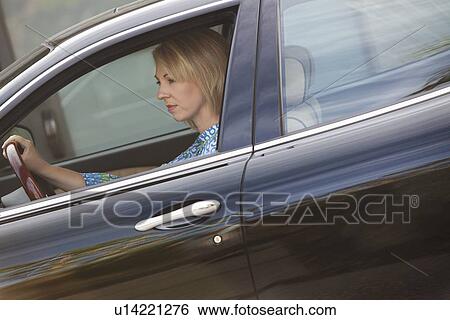 Woman drives luxury vehicle with window open View Large Photo Image Stock Photograph - Woman drives luxury vehicle with window open. Fotosearch