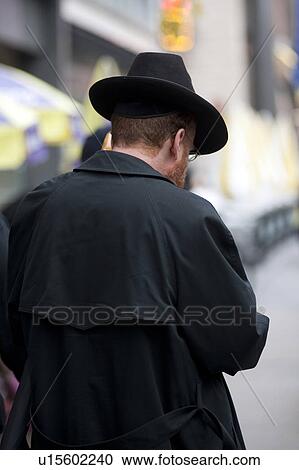 Stock Image - Back view of a man wearing a hat in Manhattan, New York City, U. S. A.. Fotosearch