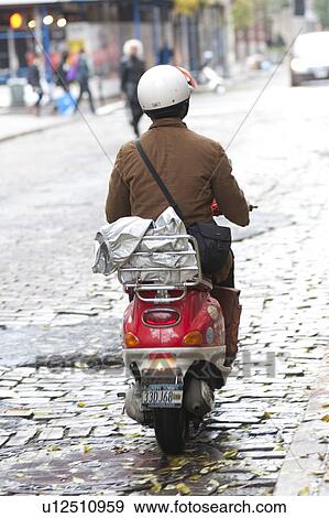 Stock Photo - Back view of a person riding a scooter in Manhattan, New York City, U. S. A. . Fotosearch