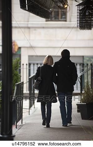 Stock Image - Couple walking on a sidewalk in Boston, Massachusetts, USA. Fotosearch