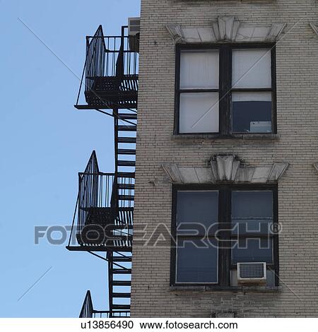 Stock Image - Exterior fire escape on building in Manhattan, New York City, U. S. A.. Fotosearch
