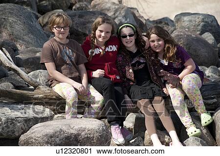Stock Image - Four friends posing on the shoreline of Winnipeg Beach, Manitoba, Canada. Fotosearch