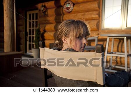 Stock Image - Girl sitting in a chair in Gimli, Manitoba, Canada. Fotosearch