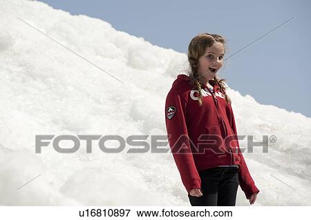Stock Photo - Girl standing on a pile of snow at Winnipeg Beach, Manitoba, Canada. Fotosearch