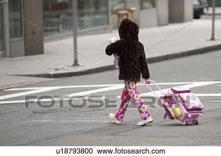 Girl with a suitcase walking across a street in Boston, Massachusetts, USA View Large Photo Image Stock Image - Girl with a suitcase walking across a street in Boston, Massachusetts, USA. Fotosearch