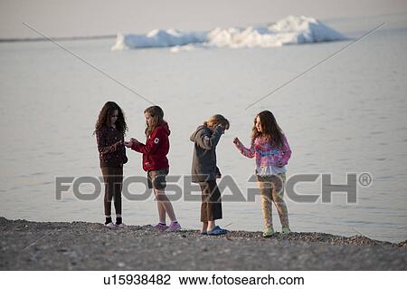 Stock Image - Girls walking along the beach at Gimli, Manitoba, Canada. Fotosearch
