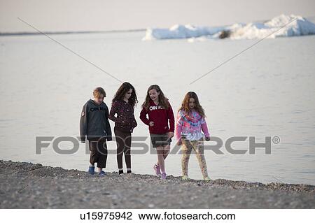 Stock Image - Girls walking along the beach at Gimli, Manitoba, Canada. Fotosearch