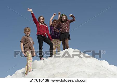 Stock Photo - Group of girls standing on a pile of snow at Winnipeg Beach, Manitoba, Canada. Fotosearch