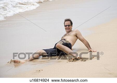 Man laying on the sand along shoreline in Bali View Large Photo Image Picture - Man laying on the sand along shoreline in Bali. Fotosearch