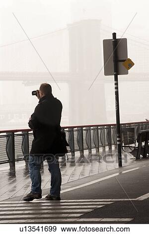 Man taking pictures on Brooklyn Bridge in Manhattan, New York City, U. S. A. View Large Photo Image Stock Photo - Man taking pictures on Brooklyn Bridge in Manhattan, New York City, U. S. A.. Fotosearch