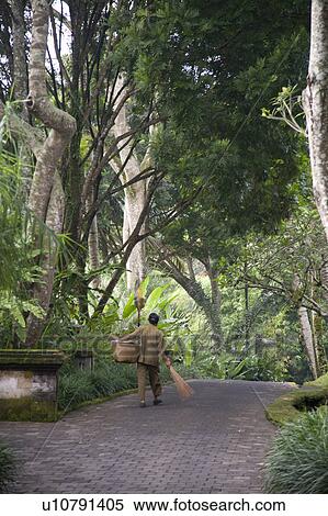 Stock Photography - Man walking along pathway in Bali. Fotosearch