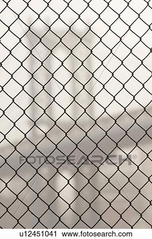Stock Image - Manhattan Bridge through a chain link fence in Manhattan, New York City, U. S. A.. Fotosearch