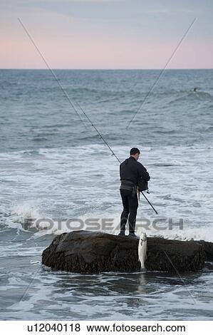 Stock Photo - People fishing off the Hampton shoreline. Fotosearch