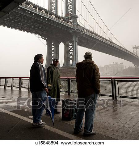 Picture - People on walkway under Manhattan Bridge in Manhattan, New York City, U. S. A.. Fotosearch