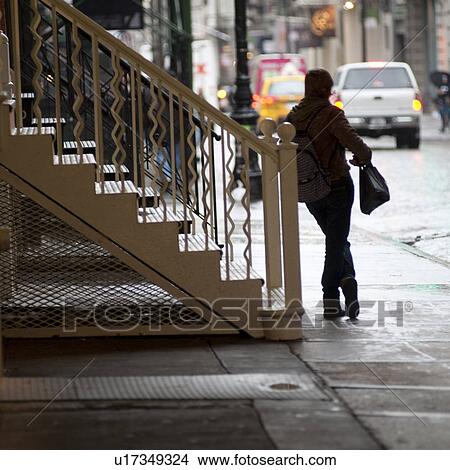 Picture - Person leaning against staircase in Manhattan, New York City, U. S. A.. Fotosearch