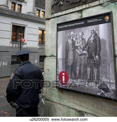 Stock Photography - Police officer in front of billboard in Manhattan, New York City, U. S. A.. Fotosearch