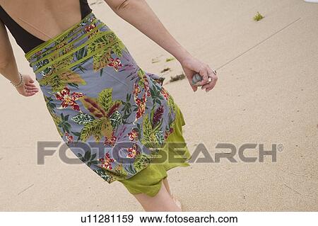 Stock Photo - Sarong on woman walking along the beach in Bali. Fotosearch
