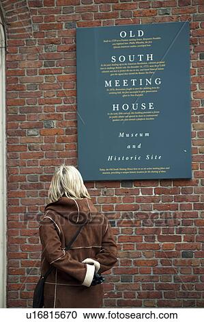 Stock Image - Woman looking at the Old South Meeting House sign in Boston, Massachusetts, USA. Fotosearch