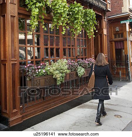 Stock Image - Woman on a sidewalk in Boston, Massachusetts, USA. Fotosearch