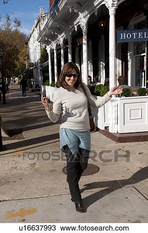 Woman walking down the sidewalk in Sag Harbour View Large Photo Image Stock Image - Woman walking down the sidewalk in Sag Harbour. Fotosearch