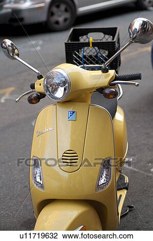 Stock Image - Yellow scooter on the street in Boston, Massachusetts, USA. Fotosearch
