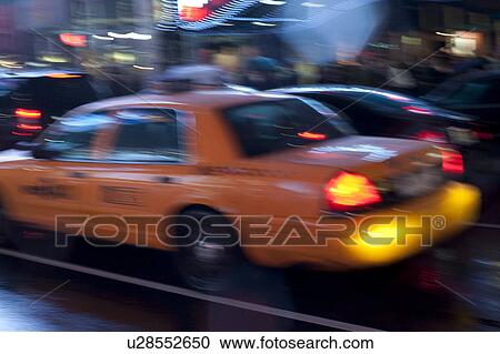 Stock Image - Yellow Taxis on streets in Manhattan, New York City, U. S. A.. Fotosearch