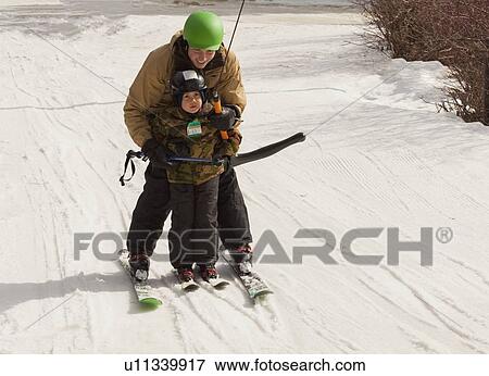 Stock Photo - red deer, alberta, canada; a father teaching his young son how to ski. Fotosearch
