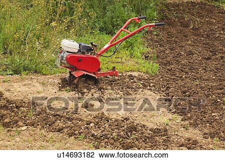 Stock Image - torremolinos, malaga, andalusia, spain; a motor hoe in a partly ploughed field. Fotosearch