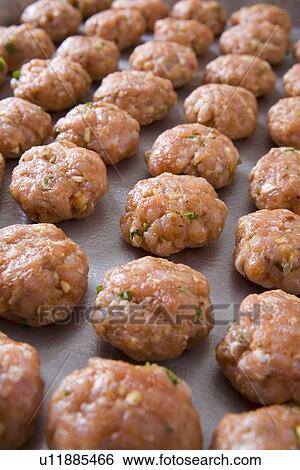 Stock Photograph - tray of raw meatballs on a baking sheet. Fotosearch