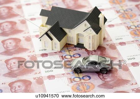 Stock Image - A model house and a toy car on Chinese Currency. Fotosearch