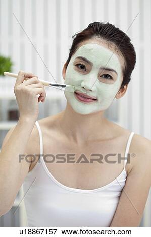 Beauty Treatment, Woman applying lotion on her face with a make-up brush View Large Photo Image Stock Photo - Beauty Treatment, Woman applying lotion on her face with a make-up brush. Fotosearch