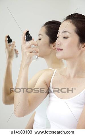 Beauty Treatment, Woman holding a bottle spraying on face for skin care View Large Photo Image Stock Image - Beauty Treatment, Woman holding a bottle spraying on face for skin care. Fotosearch