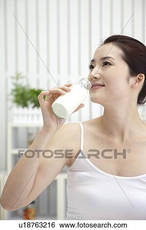 Beauty Treatment, Woman looking away and drinking a bottle of milk View Large Photo Image Stock Photograph - Beauty Treatment, Woman looking away and drinking a bottle of milk. Fotosearch