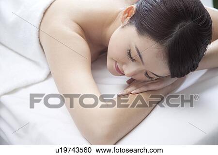 Beauty Treatment, Woman lying on front on massage table with eyes closed View Large Photo Image Stock Image - Beauty Treatment, Woman lying on front on massage table with eyes closed. Fotosearch