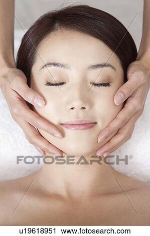 Stock Image - Beauty Treatment, Woman lying with eyes closed and enjoying massaging. Fotosearch