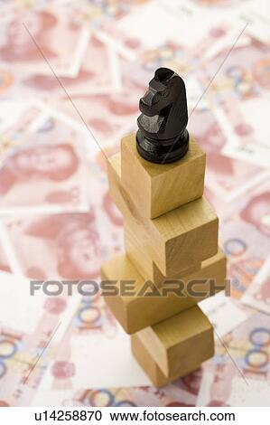Stock Image - Chinese Currency and chess on blocks. Fotosearch