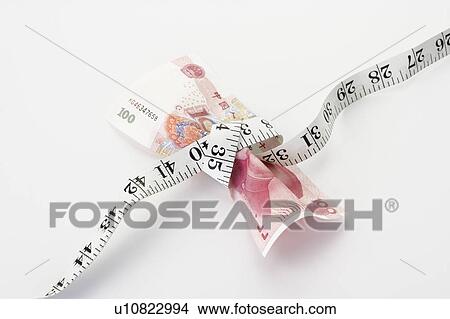 Chinese Currency tied up by a measuring tape View Large Photo Image Picture - Chinese Currency tied up by a measuring tape. Fotosearch