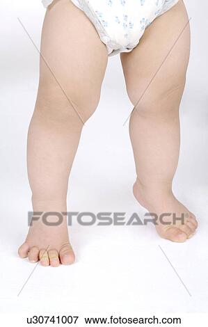 Stock Photo - Close-up of baby boy's legs with diaper. Fotosearch