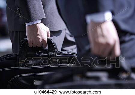 Close-up of businessmen well-dressed holding briefcase View Large Photo Image Stock Photo - Close-up of businessmen well-dressed holding briefcase. Fotosearch