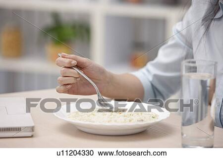 Stock Image - Close-up of hand holding fork for dinner. Fotosearch