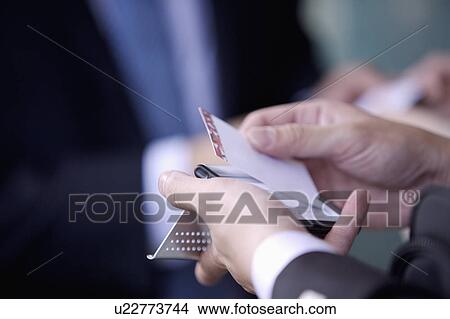Picture - Close-up of human's hands holding a rotary card file. Fotosearch