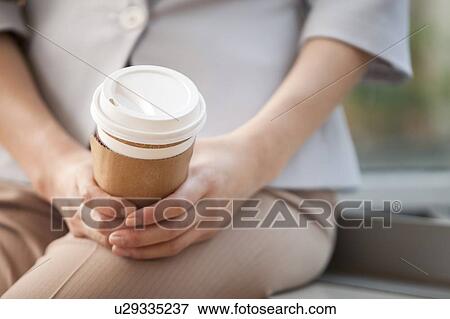 Stock Photo - Close-up of woman holding a coffee cup. Fotosearch