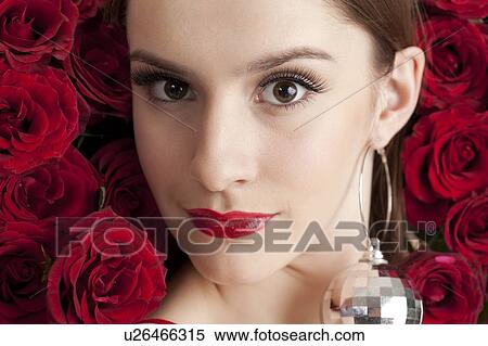 Close-up of young woman's face with red roses in background View Large Photo Image Stock Photography - Close-up of young woman's face with red roses in background. Fotosearch