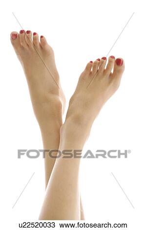 Stock Image - Close-up of young woman's feet with red nail polish. Fotosearch