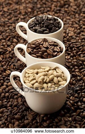 Stock Photograph - Coffee Bean, Coffee Culture, Close-up of three cups of coffee beans on a stack of coffee beans. Fotosearch