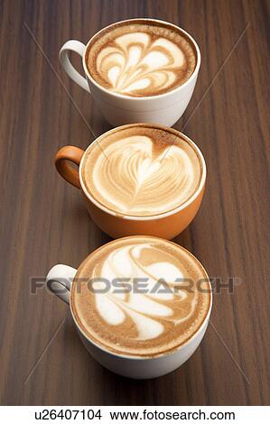 Picture - Coffee, Close-up of three cups of cappuccino with pattern on the table. Fotosearch
