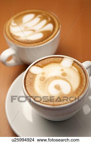 Picture - Coffee, Close-up of two cups of cappuccino with pattern on the table. Fotosearch